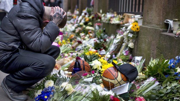 Mourners place flowers outside of synagogue. Photo Courtesy of BBC NEWS.