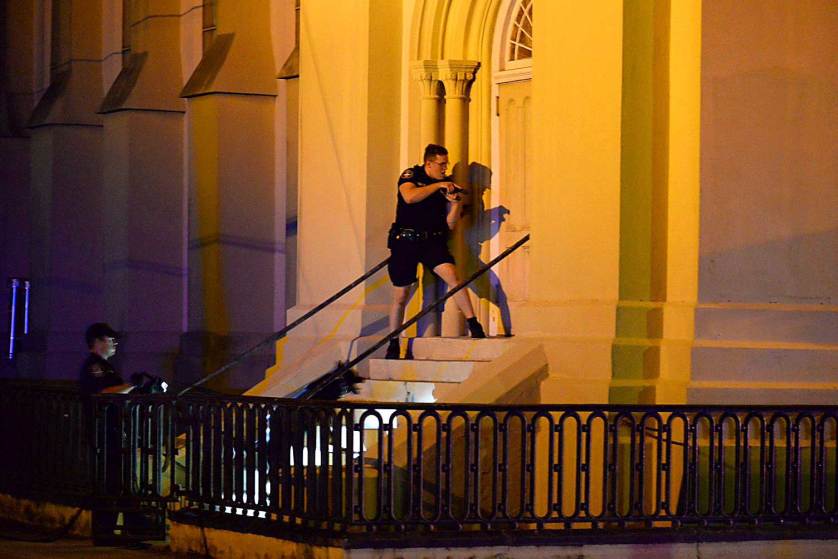 Charleston police officers search for a shooting suspect outside the Emanuel AME Church, in downtown Charleston, S.C. on Wednesday, June 17, 2015. A white man opened fire during a prayer meeting inside the historic black church killing several people. The shooter remained at large Thursday morning. Photo Courtesy of Matthew Fortner/The Post And Courier via AP.