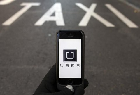 Uber app on smartphone over reserved lane for taxis in Madrid. Via businessinsider.com.